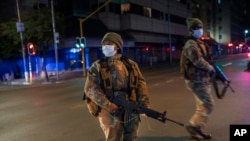 South African Defense Forces patrol downtown Johannesburg, South Africa, Friday, March 27, 2020. Police and army started patrolling moments after South Africa went into a nationwide lockdown for 21 days in an effort to mitigate the spread to the…