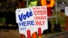 Signs direct voters to a ballot drop-off location, in Washington Park in Denver, Oct. 25, 2024.