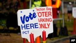 Signs direct voters to a ballot drop-off location, in Washington Park in Denver, Oct. 25, 2024.