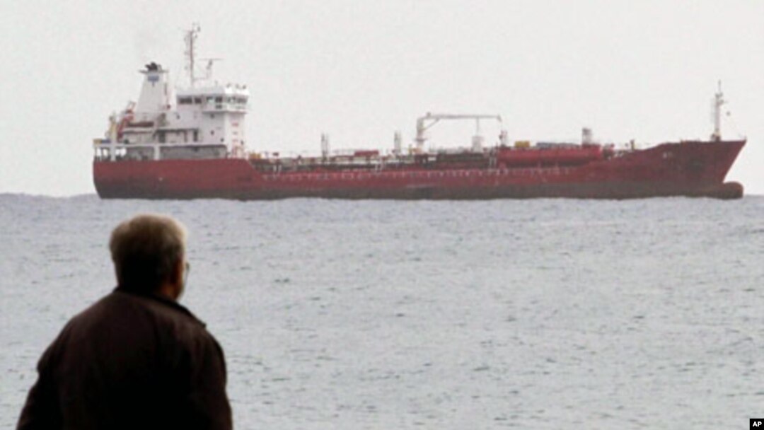 A man looks at the Saint Vincent-flagged "Chariot" cargo ship as it sails out of the port of the southern Cypriot city of Limassol, January 11, 2012.
