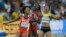 FILE: Trinidad and Tobago's Kelly-Ann Baptiste , left, collides with United States' Tori Bowie, center, and Jamaica's Natasha Morrison, right, after their women's 100m semifinal at the World Athletics Championships at the Bird's Nest stadium in Beijing, Monday, Aug. 24, 2015.
