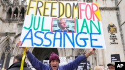 Manifestantes alzan carteles en los que se lee "libertad a Julian Assange" frente a los tribunales de Londres, el martes 20 de febrero de 2024. El fundador de WikiLeaks, Julian Assange, presenta su alegato final contra su inminente extradición a Estados Unidos. 