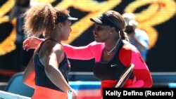 Serena Williams (à dr.) embrasse Naomi Osaka à l'issue de leur demi-finale, le 18 février 2021 à Melbourne, en Australie.