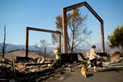 Stephanie LaFranchi, right, and Ashley LaFranchi examine the remains of their family's Oak Ridge Angus ranch, leveled the Kincade Fire, in Calistoga, Calif., Oct. 28, 2019.