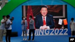 Chinese President Xi Jinping is seen on a screen at a booth promoting winter sports ahead of the 2022 Beijing Winter Olympics during the China International Fair for Trade in Services (CIFTIS) in Beijing, China on Sunday, Sept. 5, 2021. (AP Photo/Ng Han Guan)