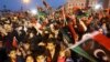 Libyans wave national flags as they attend a celebration marking the seventh anniversary of the Libyan revolution which toppled late leader and strongman Moamer Kadhafi, in the capital Tripoli's Martyrs Square, Feb. 17, 2018.