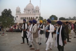 FILE - In this Nov. 28, 2018 file photo, Indian Sikh pilgrims visit Gurdwara Darbar Sahib, the shrine of their spiritual leader Guru Nanak Dev in Kartarpur, Pakistan.