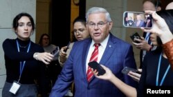 FILE PHOTO: U.S. Senator Robert Menendez (D-NJ) is trailed by reporters after departing the Senate Democratic Caucus, in Washington