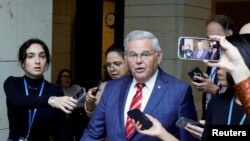 FILE - U.S. Senator Robert Menendez is trailed by reporters after departing the Senate Democratic Caucus in Washington, Sept. 28, 2023. 