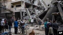 Warga Palestina memeriksa kerusakan bangunan tempat tinggal pasca serangan udara Israel di Rafah, Jalur Gaza selatan, Minggu, 24 Maret 2024. (AP/Fatima Shbair)