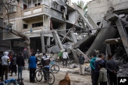 FILE—Palestinians inspect the damage of residential buildings after an Israeli airstrike in Rafah, southern Gaza Strip, Sunday, March 24, 2024.