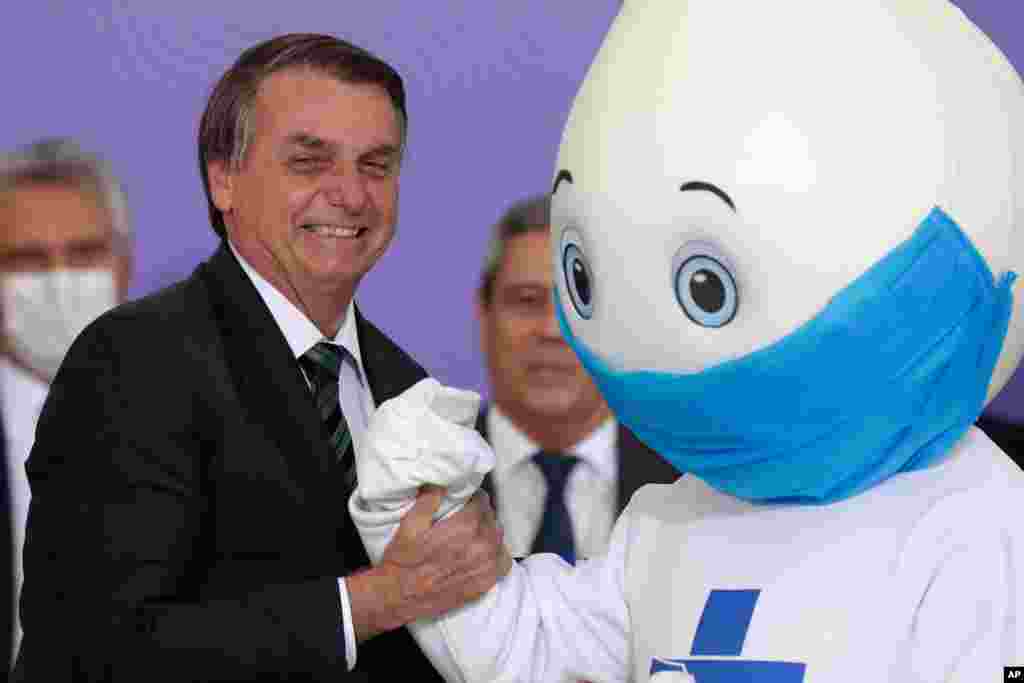 자이르 보우소나루 브라질 대통령이 브라질리아 대통령궁에서 전국 백신 캠페인의 마스코트인 &#39;제 코틴아 (작은 방울의 조셉)&#39;과 사진촬영을 했다. 