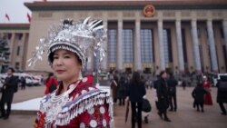 资料照片：一名身穿少数民族服饰的代表在北京人民大会堂举行的全国人大开幕式结束后离开。(2026年3月5日)