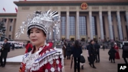 资料照片：一名身穿少数民族服饰的代表在北京人民大会堂举行的全国人大开幕式结束后离开。(2026年3月5日)