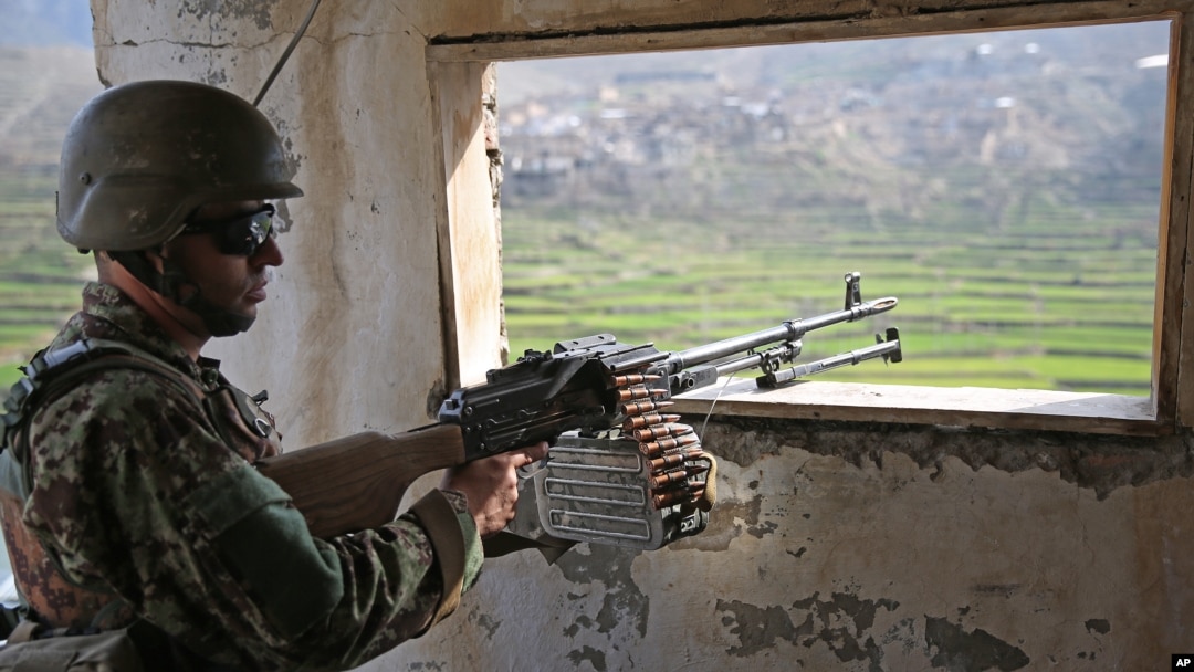 FILE - An Afghan National Army (ANA) soldier stands guard in Narai military camp in Ghazi Abad district, Feb. 23, 2014.