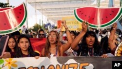 FILE - Activists demonstrate for climate justice and a ceasefire in the Israel-Hamas war at the COP28 U.N. Climate Summit, December 9, 2023, in Dubai, United Arab Emirates.