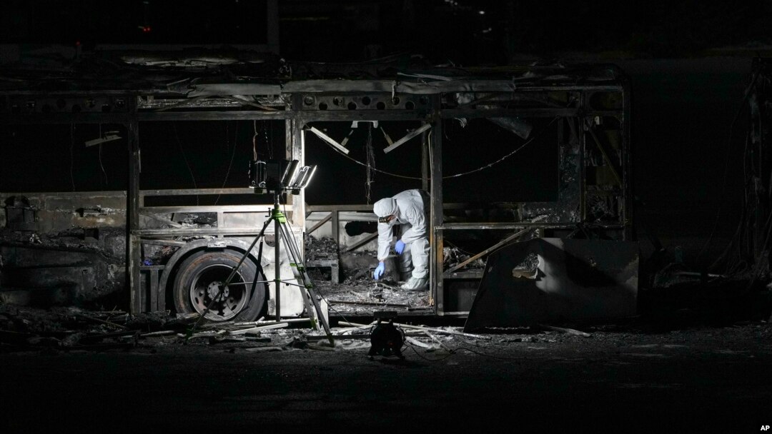 An Israeli police officer inspects the scene of one of a series of bus explosions in what authorities said appeared to be a militant attack in Bat Yam, central Israel, Feb. 20, 2025.
