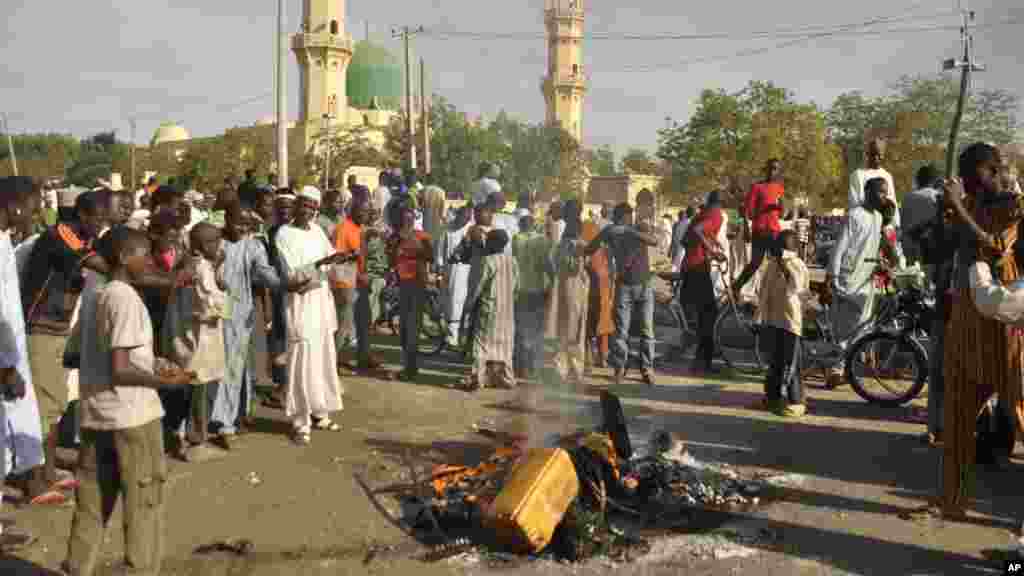 Mutane sun taru su na kallo a inda bam ya tashi a babban Masallacin Jumma&#39;a na Kano, Jumma&#39;a 28 Nuwamba, 2014. Mutane da yawa sun rasa rayukansu, kuma jami&#39;ai suka ce watakila yawan wadanda zasu hallaka zai karu.