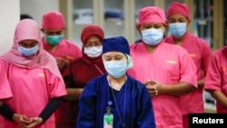 Para tenaga medis mengenakan masker pelindung berdoa untuk para pasien virus corona (Covid-19) saat pengarahan di ruang gawat darurat di Rumah Saki Persahabatan di Jakarta, 14 Mei 2020. (Foto: Reuters)