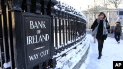 Seorang perempuan tengah melintas di depan kantor cabang Bank Irlandia di Central Dublin (Foto: dok). Para ahli ekonomi dan kelompok bisnis Irlandia menyerukan agar pemerintah melonggarkan program penghematan.