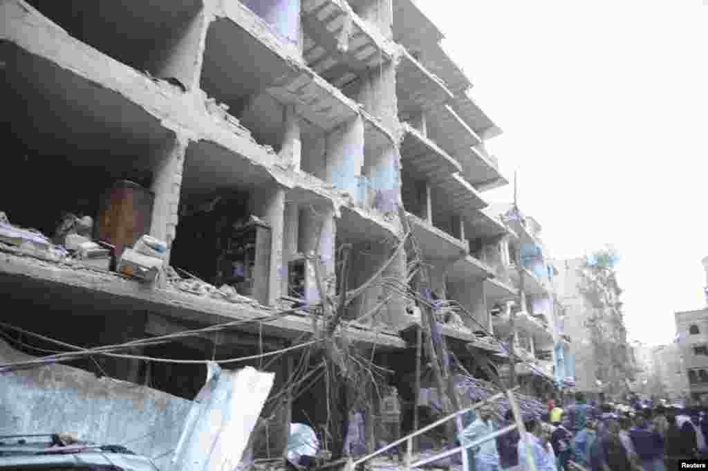 A crowd gathers in front of damaged buildings after a car bomb exploded at Daf al-Shok district, in Damascus, Syria, October 26, 2012, in this photograph released by Syria's national news agency SANA.