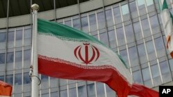 FILE - The Iranian flag waves outside of the UN building that hosts the International Atomic Energy Agency office inside in Vienna, Austria, July 10, 2019. 