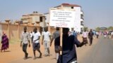 A demonstrator holds a placard during a rally protesting the United States' unilateral arms embargo on the country, in Juba, South Sudan, Feb. 6, 2018. 