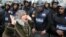 A woman reacts as she stands before riot policemen separating opponents of Egyptian President Mohamed Morsi and Islamist supporters of the president in Alexandria, Egypt, December 21, 2012.