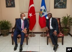 Turkey's Foreign Minister Mevlut Cavusoglu, left, speaks with Claude Joseph, Minister of Foreign Affairs of the Republic of Haiti, during a meeting, in Port-au-Prince, Haiti, Monday, Aug. 17, 2020. (Cem Ozdel/Turkish Foreign Ministry via AP, Pool )