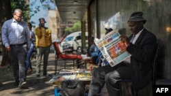 Seorang pria tampak membaca surat kabar terkemuka Kenya, Daily Nation, yang memberitakan tentang pemakzulan terhadap Wakil Presiden Kenya Rigathi Gachagua, di sebuah lapak koran di sudut Kota Nairobi, pada 9 Oktober 2024. (Foto: AFP/Tony Karumba)