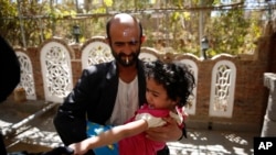  FILE - A Yemeni health worker marks a finger of a girl after giving her a polio vaccination during a house-to-house polio immunization campaign in Sanaa, Yemen.