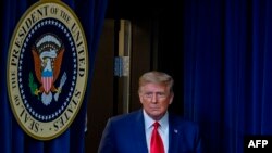 El presidente Donald Trump entra a la sala de prensa de la Casa Blanca para una conferencia de prensa sobre la pandemia del coronavirus, el 8 de diciembre de 2020.