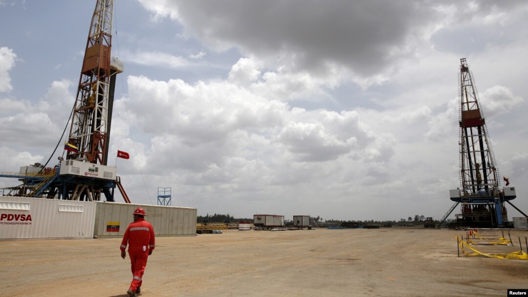 ARCHIVO - Un trabajador de un campo petrolero camina junto a las plataformas de perforación en un pozo de petróleo operado por la petrolera estatal de Venezuela PDVSA, en el rico cinturón petrolero del Orinoco, el 16 de abril de 2015.