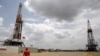 FILE PHOTO: An oilfield worker walks next to drilling rigs at an oil well operated by Venezuela's state oil company PDVSA, in the oil-rich Orinoco belt, April 16, 2015.. REUTERS/Carlos Garcia Rawlins/File Photo