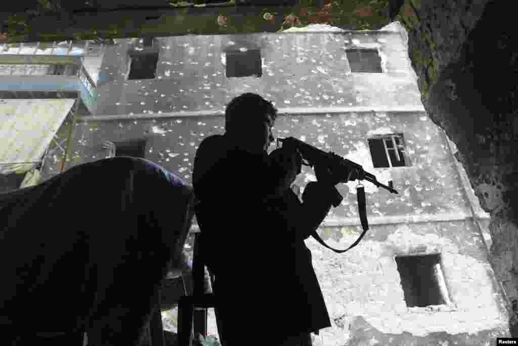 A Free Syrian Army fighter takes position in a damaged house in the Aghyol area of Aleppo, Jan. 11, 2014. 