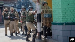 An Indian paramilitary soldier aims his slingshot at Kashmiri protesters near the site of a gunbattle in Srinagar, Indian-controlled Kashmir, May 5, 2018. Fierce clashes erupted when residents in solidarity with the rebels tried to march to the gunbattle site.