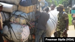 Un gendarme centrafricain prospectant des bagages à un barrage routier, en novembre 2017. (VOA/Freeman Sipila)