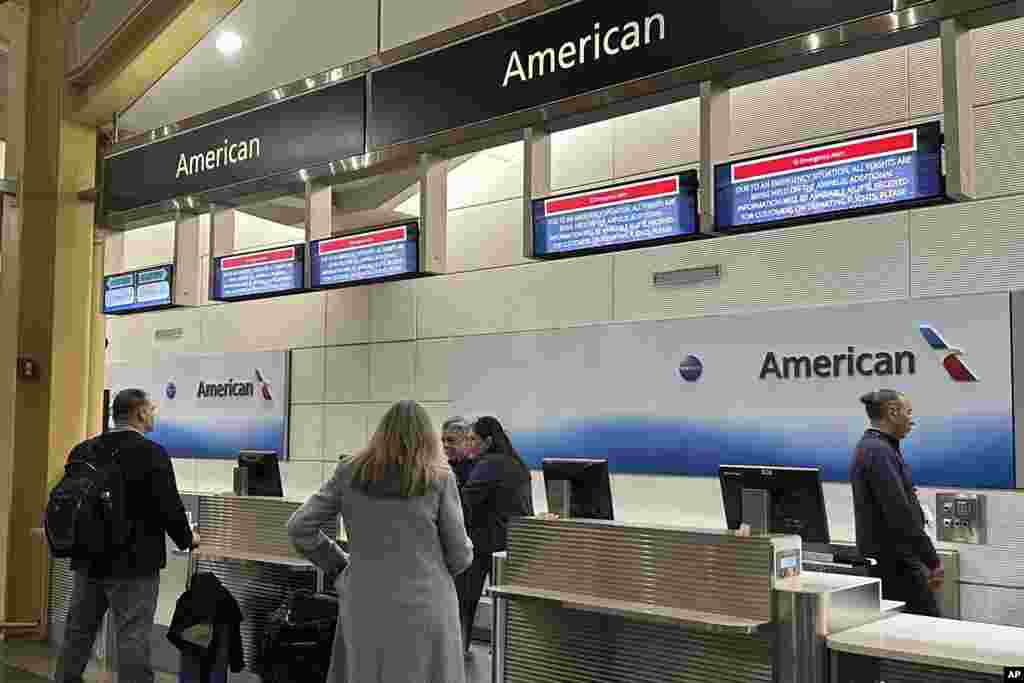 Signs display an &quot;Emergency Alert&quot; above an American Airlines counter in the terminal at Ronald Reagan Washington National Airport, Jan. 29, 2025, in Arlington.