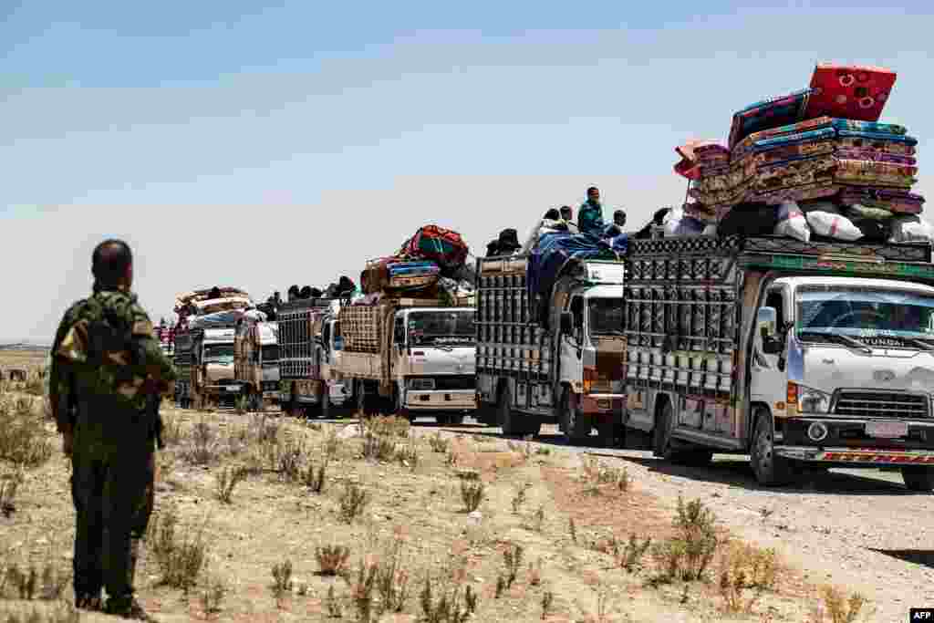 Syrian families sit in trucks after being released from the Kurdish-run Al-Hol camp, which holds relatives of suspected Islamic State (IS) group fighters, in the northeastern Syrian Hasakeh governorate.