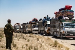 Syrian families sit in trucks after being released from the Kurdish-run Al-Hol camp, which holds relatives of suspected Islamic State (IS) group fighters, in the northeastern Syrian Hasakeh governorate.
