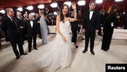 Michelle Yeoh pose on the champagne-colored red carpet during the Oscars arrivals at the 95th Academy Awards in Hollywood, Los Angeles, California, March 12, 2023.