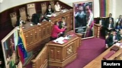 A video grab from government television shows an unidentified man running to Venezuela's President Nicolas Maduro (C) during his speech after Maduro was sworn into office, in Caracas April 19, 2013. 