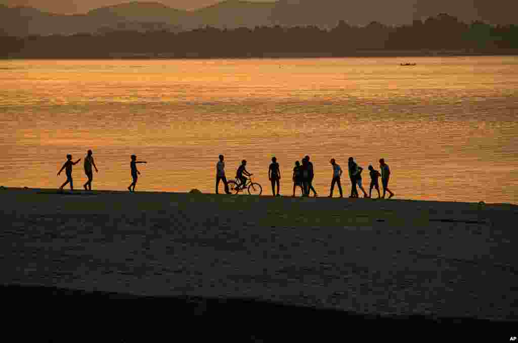 Boys play along the river Brahmaputra as the sun sets in Gauhati, India.