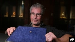 Malcolm Weale, a detectorist who found the item displays an early medieval silver penny of Guthrum of East Anglia, the first silver coin minted by a Viking ruler in Britain, at the British Museum's annual treasure launch in London, Feb. 11, 2025.