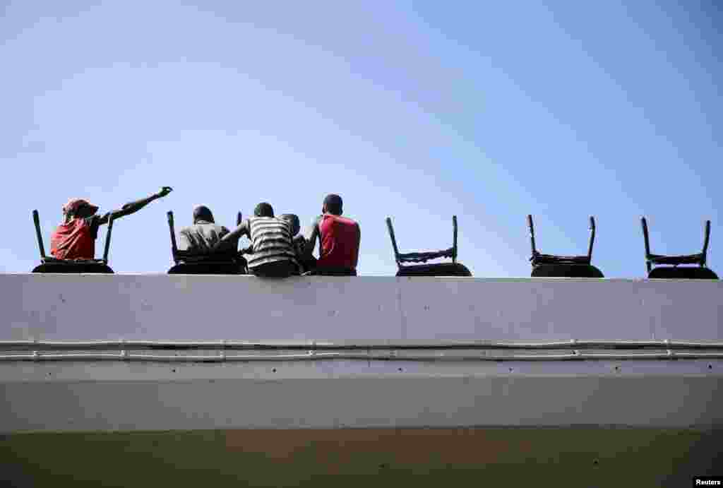 Labourers rest with their wheelbarrows on a bridge in the Obalende district of Lagos.