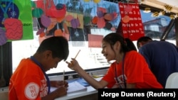 Migrant children take English lessons at a bus converted in a classroom as part of Schools On Wheels program by California's 'Yes We Can' organisation, in Tijuana, Mexico August 2, 2019.