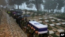 FILE - Israeli soldiers carry the flag-draped casket of reservist Elkana Vizel during his funeral at Mt. Herzl military cemetery in Jerusalem, January 23, 2024.