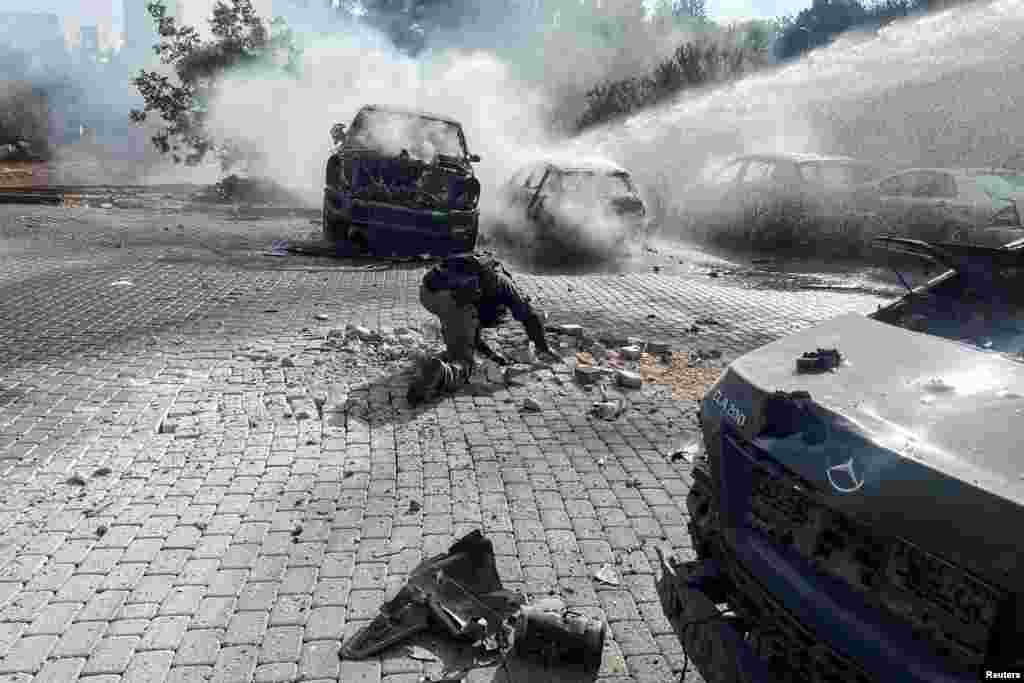 An Israeli police officer investigates at the scene where a rocket fired from Lebanon landed in Israel, amid cross-border hostilities between&nbsp;Hezbollah&nbsp;and Israel, near the border with Lebanon in northern Israel.