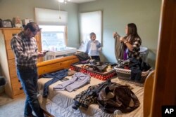 Shane Alderson, his wife, Alisha, and their daughter, Adeline, 5, pack for a trip to Idaho at the family's home in Baker City, Ore., on Friday, Sept. 1, 2023. (AP Photo/Kyle Green)