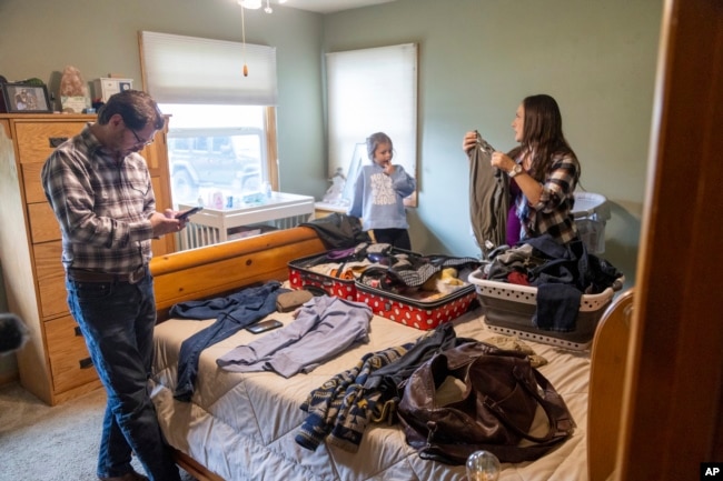 Shane Alderson, his wife, Alisha, and their daughter, Adeline, 5, pack for a trip to Idaho at the family's home in Baker City, Ore., on Friday, Sept. 1, 2023. (AP Photo/Kyle Green)